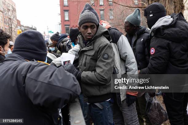 Single migrant men, mostly from West Africa, congregate in Tompkins Square Park as volunteers give away food and clothing, January 27 in the East...