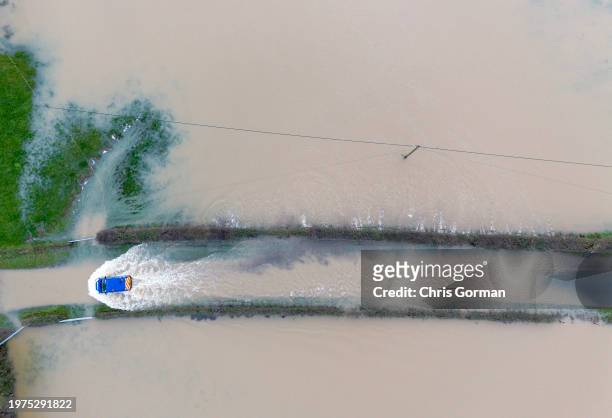 Car navigates a flooded road after the River Rother burst its banks on January 5,2024 near Petworth, England. Days of heavy rainfall have exacerbated...