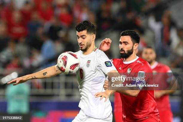 Saeid Ezatolahi of Iran and Omar Khrbin of Syria compete for the ball during the AFC Asian Cup Round of 16 match between Iran and Syria at Abdullah...