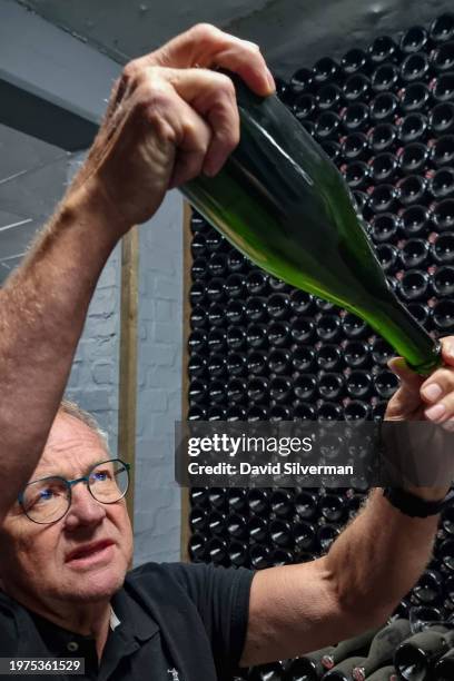 Winemaker Pieter Ferreira checks the lees of aging Pinot Noir Cap Classique sparkling wine at the Graham Beck Estate winery on January 24, 2024 near...