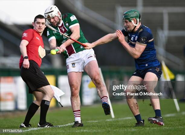 Galway , Ireland - 3 February 2024; Michael Daly of Westmeath passes under pressure from Gavin Lee of Galway, as linesman Ciarán O'Regan looks on,...