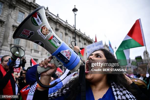 Pro-Palestinian supporter chants slogans in a loudspeaker as she takes part in a National March for Palestine in central London on February 3, 2024....