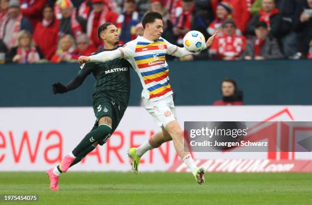 Justin Njinmah of Bremen and Anthony Caci of Mainz battle for the ball during the Bundesliga match between 1. FSV Mainz 05 and SV Werder Bremen at...