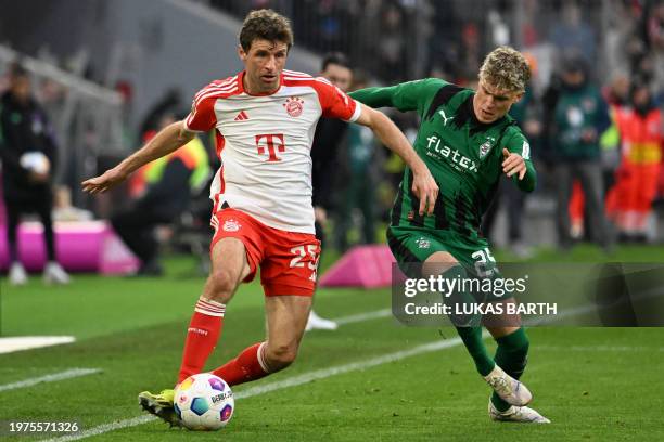 Bayern Munich's German forward Thomas Mueller and Moenchengladbach's German midfielder Robin Hack vie for the ball during the German first division...