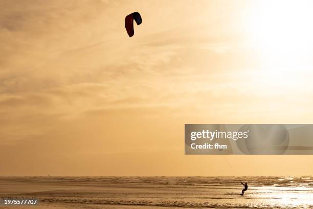 kitesurfer on the north sea at sunset - st peter ording stock pictures, royalty-free photos & images