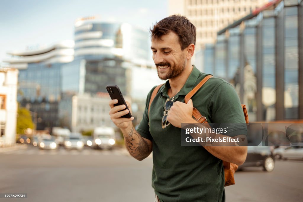 Man With Smartphone in Hand Browsing Social Media on the Street