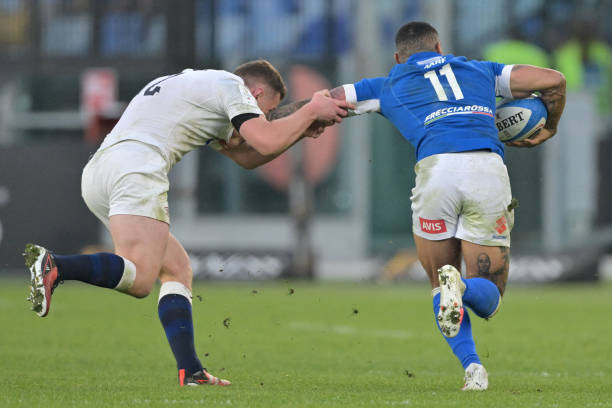 Italy's wing Monty Ioane escapes tackle from England's centre Fraser Dingwall on his way to scoring a try during the Six Nations rugby union...
