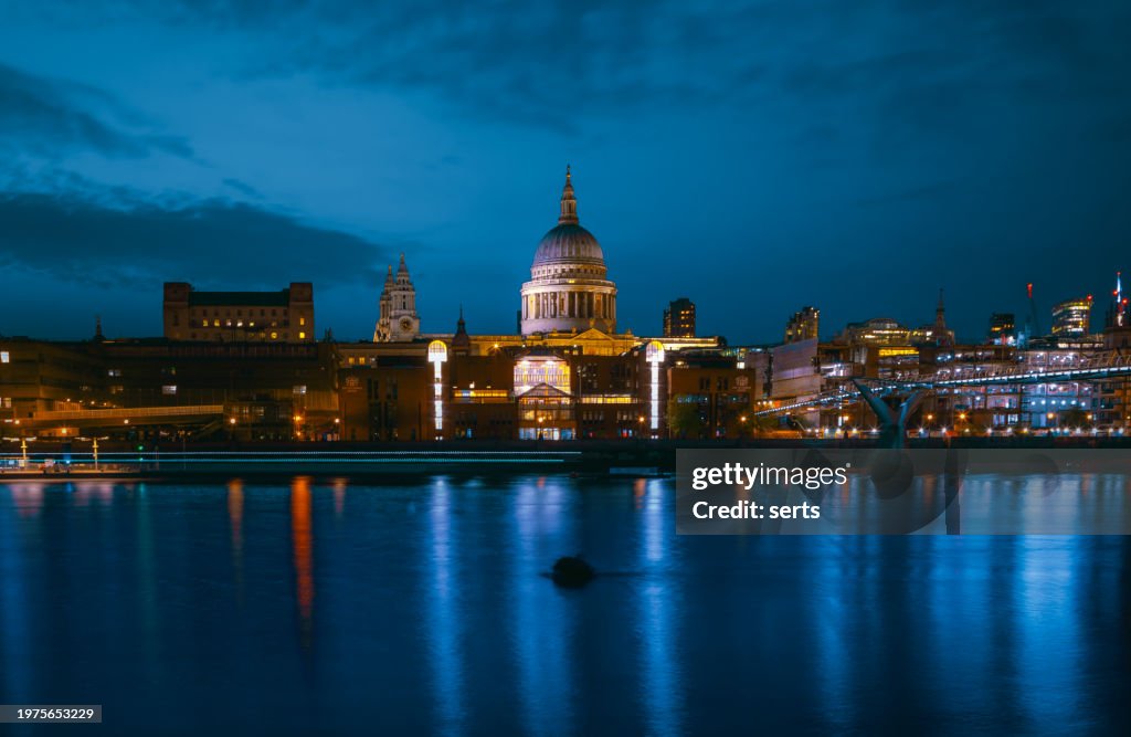 St Paul's Cathedral and Millenium Bridge at night in London, UK