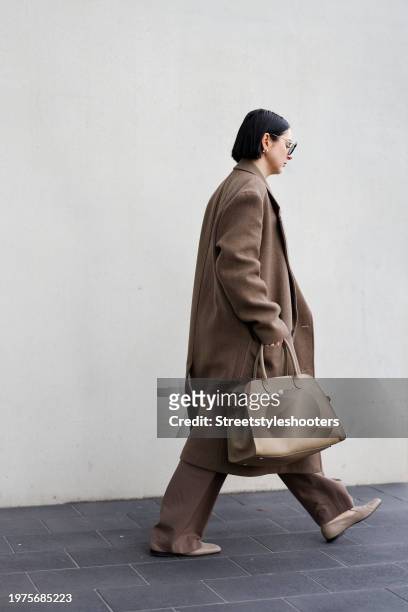 Influencer Maria Barteczko, wearing a brown oversized long wool coat by Zara, a brown v-neck cashmere knit sweater by Soft Goat, brown wide leg...