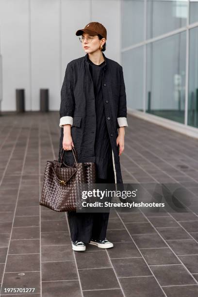Influencer Maria Barteczko, wearing a black long wrinkled effect coat by Wendykei, a black long oversized shirt by Wendykei, black wrinkled effect...