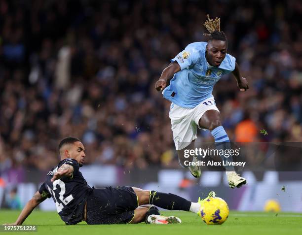 Jeremy Doku of Manchester City is challenged by Vitinho of Burnley during the Premier League match between Manchester City and Burnley FC at Etihad...