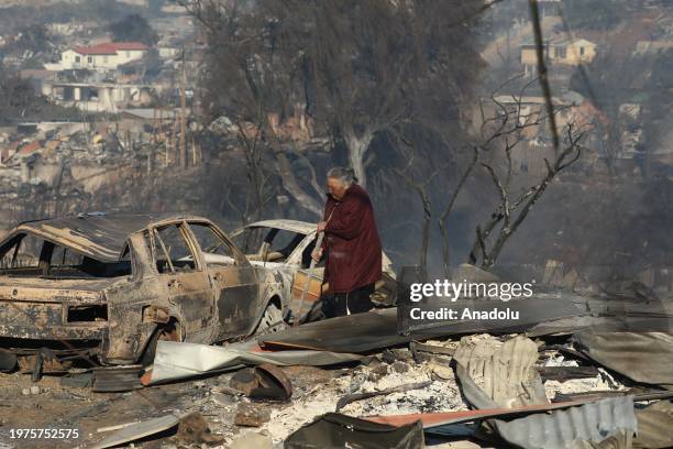 Person walks past destroyed houses, as a result of a forest fire that left thousands of homes burned in the hills of Vina del Mar, Chile, on February...