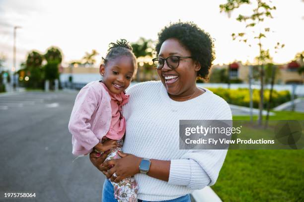 happy african american mom and daughter on a walk - young black woman photos et images de collection