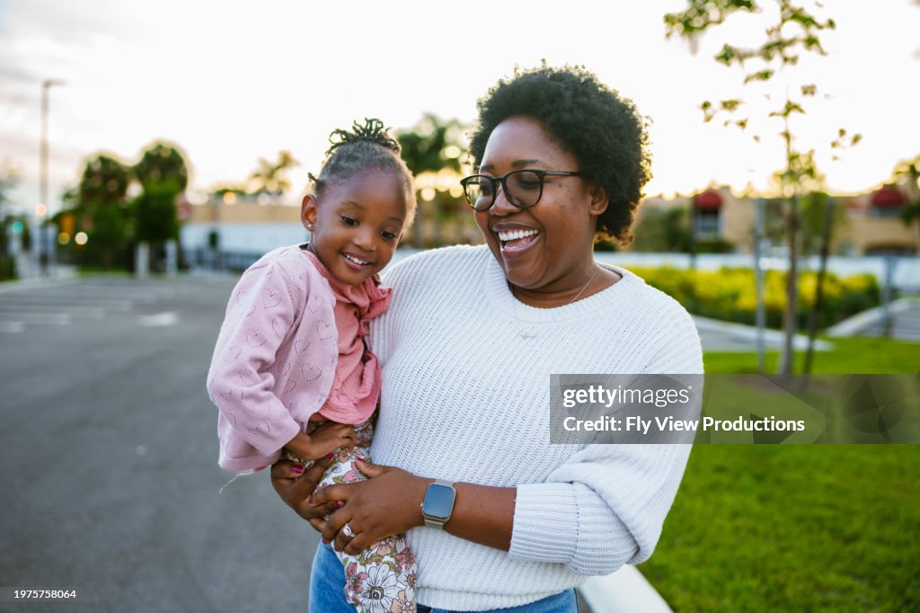 Happy African American mom and daughter on a walk