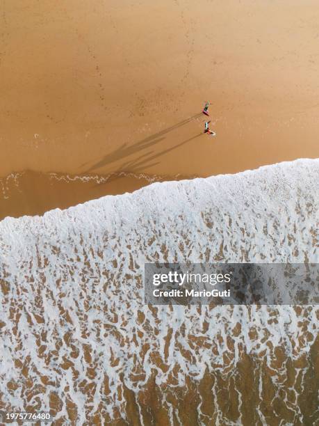 beach with surfers from above - waters edge stock pictures, royalty-free photos & images