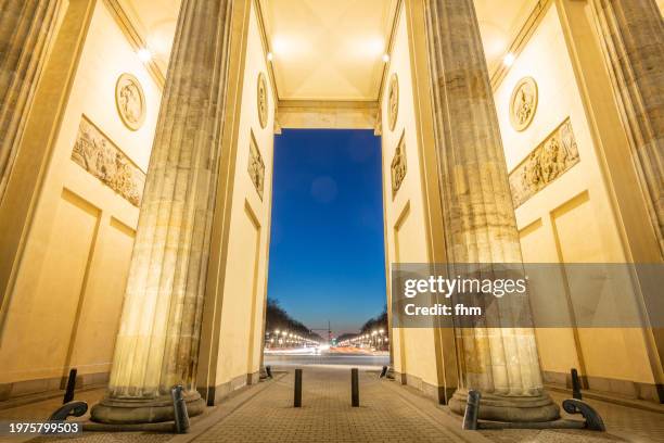 illuminated columns of the brandenburg gate at blue hour (berlin, germany) - mitte stock pictures, royalty-free photos & images