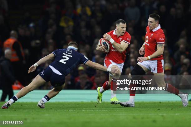 Scotland's hooker George Turner attempts to tackle Wales' scrum-half Gareth Davies running with the ball next to Wales' wing Josh Adams during the...