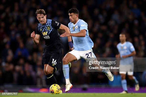 Matheus Nunes of Manchester City runs with the ball whilst under pressure from Sander Berge of Burnley during the Premier League match between...