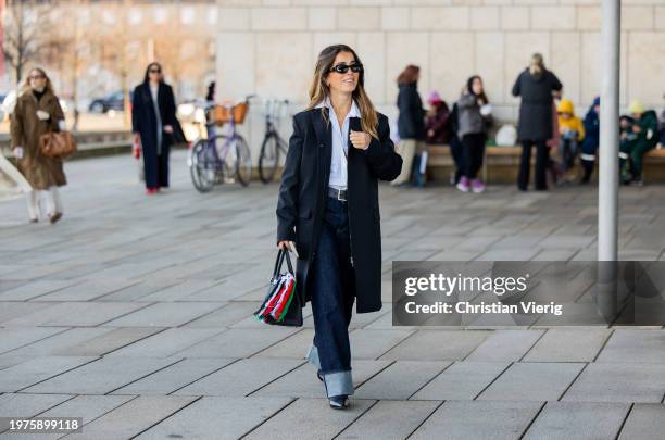 Bruna Rizik wears black jacket, dark denim jeans, Hermes bag with Palestine colors outside OpéraSport during the Copenhagen Fashion Week AW24 on...