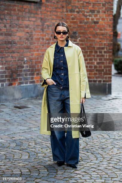 Mary L. Jean wears mustard yellow coat, black Prada bag, denim jeans, jacket outside Herskind during the Copenhagen Fashion Week AW24 on January 31,...