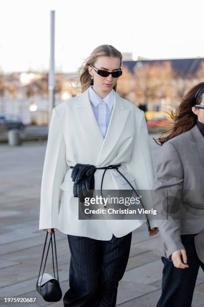 Guest wears creme white blazer, black gloves outside OpéraSport during the Copenhagen Fashion Week AW24 on January 31, 2024 in Copenhagen, Denmark.