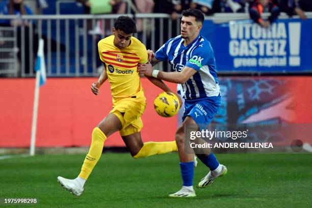Barcelona's Spanish forward Lamine Yamal is challenged by Alaves' Spanish defender Javi Lopez during the Spanish league football match between...