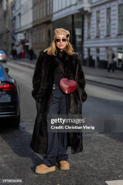 Sonia Lyson wears brown fur coat, red heat shaped Alaia bag, navy pants, beige Ugg boots, beige beret, sunglasses, brown top outside The Garment...