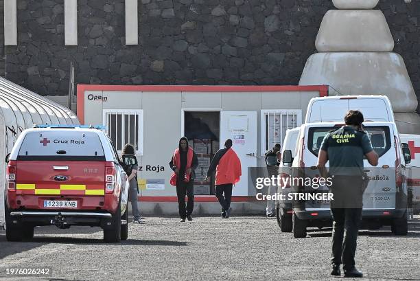 Migrants are helped by members of the Spanish Red Cross and Guardia Civil officers following their rescue by the Spanish Salvamento Maritimo vessel...