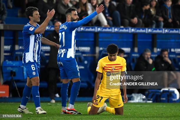 Alaves' Spanish midfielder Ander Guevara and Alaves' Algerian forward Abderrahmane Rebbach gesture as Barcelona's Spanish forward Lamine Yamal kneels...