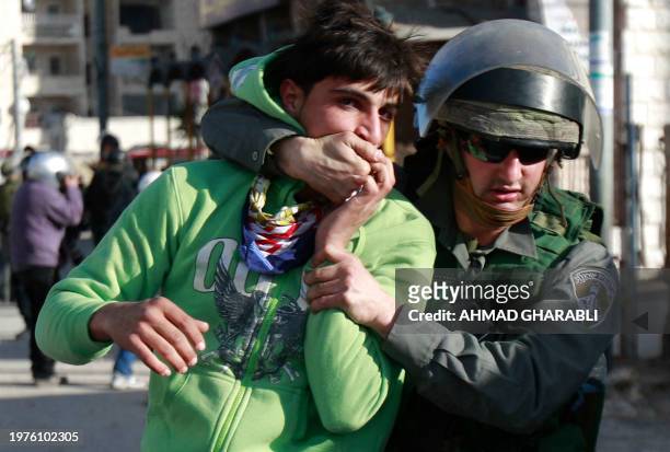 Palestinian youth is arrested by Israeli border policemen following clashes with Israeli forces at the Shuafat refugee camp in Jerusalem on February...