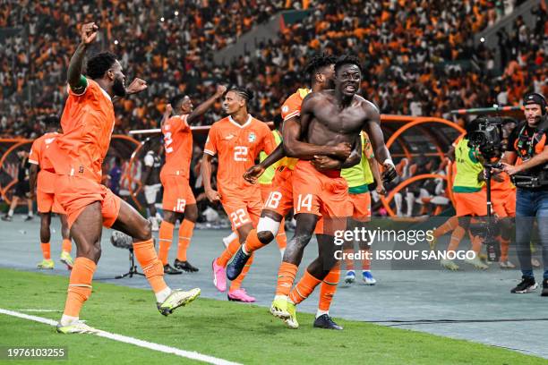 Ivory Coast's forward Oumar Diakite takes his jersey off as he celebrates with teammates after scoring his team's second goal during the Africa Cup...