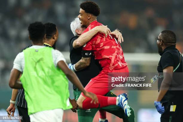 South Africa's goalkeeper Ronwen Williams celebrates with South Africa's head coach Hugo Broos after winning at the end of the Africa Cup of Nations...