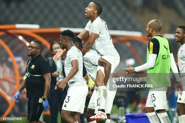 South Africa's forward Mihlali Mayambela celebrates with teammates after winning at the end of the Africa Cup of Nations 2024 quarter-final football...