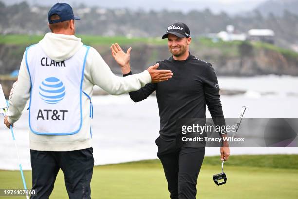 Wyndham Clark high fives his caddie at the 18th green during the third round of AT&T Pebble Beach Pro-Am at Pebble Beach Golf Links on February 3,...