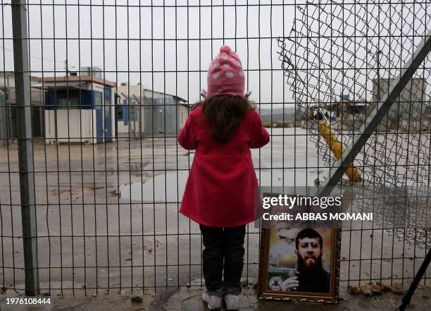 Maali, daughter of jailed Islamic Jihad spokesman Khader Adnan, stands next to a picture of her father as she takes part in a protest outside...