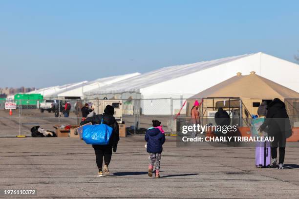 Migrants who arrived a few days ago from Eagle Pass, Texas, walk to the shelters at Floyd Bennett Field in the Brooklyn borough of New York on...