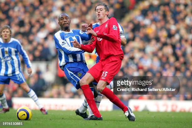 December 3: Peter Crouch of Liverpool and Damien Francis of Wigan Athletic challenge during the Premier League match between Liverpool and Wigan...