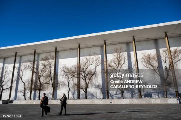Musicians walk past The John F. Kennedy Center for the Performing Arts in Washington, DC on February 3, 2024.