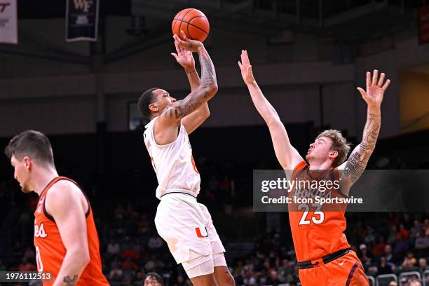 Miami guard Matthew Cleveland shoots a jump shot over Virginia Tech guard/forward Tyler Nickel in the first half as the Miami Hurricanes faced the...