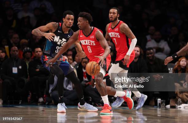 Jae'Sean Tate of the Houston Rockets drives against Nic Claxton of the Brooklyn Nets during their game at Barclays Center on January 27, 2024 in New...