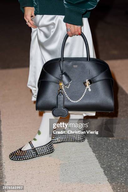 Guest wears black Ferragmo bag outside Stine Goya during the Copenhagen Fashion Week AW24 on January 31, 2024 in Copenhagen, Denmark.