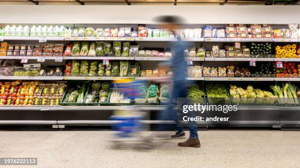 man shopping at the supermarket - blurred motion - stormarknad bildbanksfoton och bilder