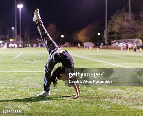 Cheerleader-Mädchen übt abends im Stadion akrobatische Übungen. Cheerleader-Mädchen übt abends im Stadion akrobatische Übungen.