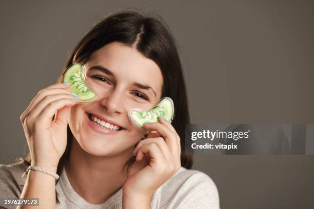 teenage girl putting eye mask - cucumber eye mask stock pictures, royalty-free photos & images