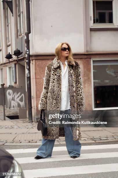 Guest wears blue jeans, a white shirt, and animal print fur coat outside The Garment during the Copenhagen Fashion Week AW24 on January 31, 2024 in...