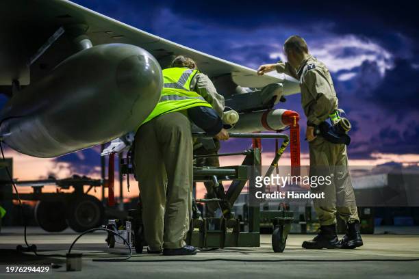 In this handout image provided by the UK Ministry of Defence, Royal Air Force Weapon Technicians prepare a RAF Typhoon FRG4 aircraft prior further...