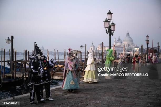 Masked revellers wearing period costumes pose during the traditional Venice Carnival, on February 4, 2024.