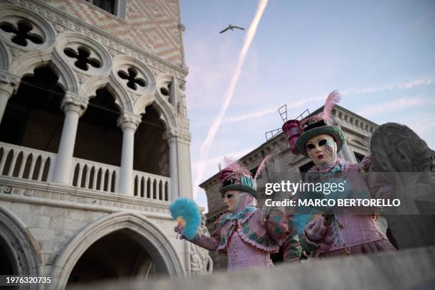 Masked revellers wearing period costumes pose during the traditional Venice Carnival, on February 4, 2024.