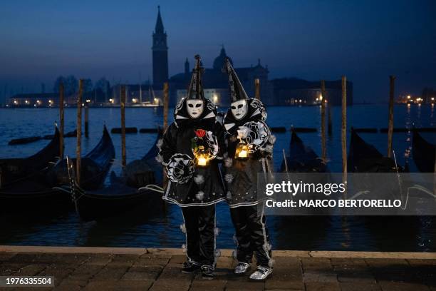 Masked revellers wearing period costumes pose during the traditional Venice Carnival, on February 4, 2024.