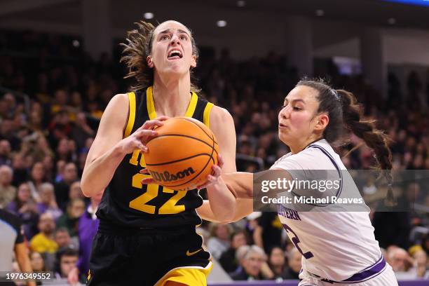 Caitlin Clark of the Iowa Hawkeyes drives to the basket against Caroline Lau of the Northwestern Wildcats during the first half at Welsh-Ryan Arena...